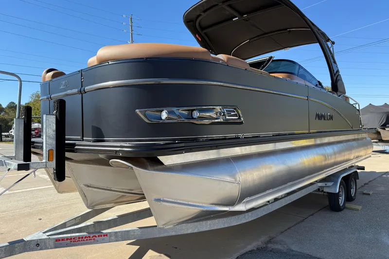 Slide: The Image of 2026 Avalon Catalina Quad Lounger Windshield pontoon boat on trailer, sleek design, outdoor setting. - 78