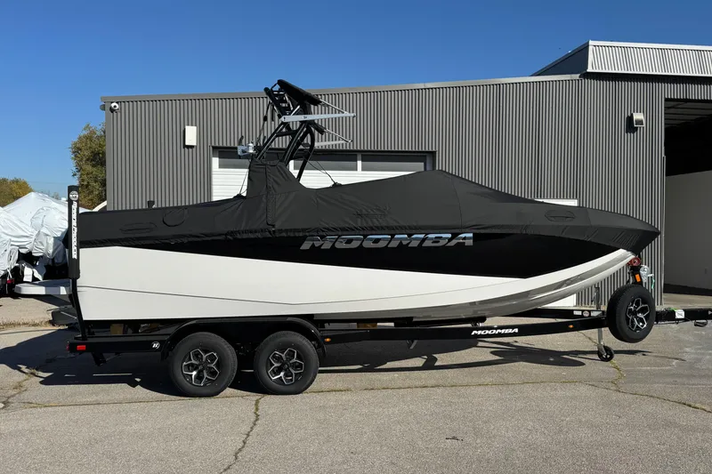 Slide: The Image of 2026 Moomba Craz boat with cover on trailer, parked outside industrial building. - 5