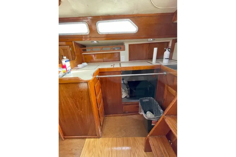Slide: The Image of 1986 Ericson 381 yacht interior kitchen with wooden cabinetry and appliances. - 17