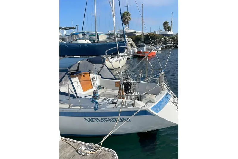 Slide: The Image of 1986 Ericson 381 sailboat docked at marina, surrounded by other boats and palm trees. - 2