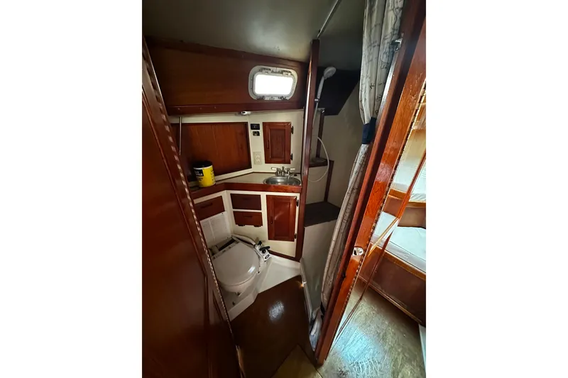 Slide: The Image of Interior of 1986 Ericson 381 sailboat bathroom with wooden cabinetry and compact design. - 21