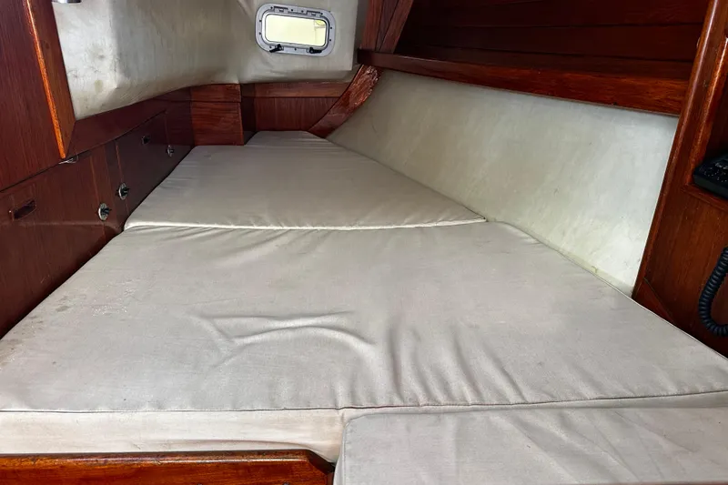 Slide: The Image of Interior cabin of 1986 Ericson 381 sailboat with cushioned berth and wooden paneling. - 23