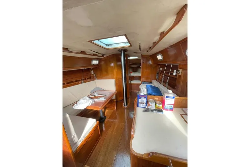 Slide: The Image of 1986 Ericson 381 sailboat cockpit with blue canopy, docked in a marina. - 6