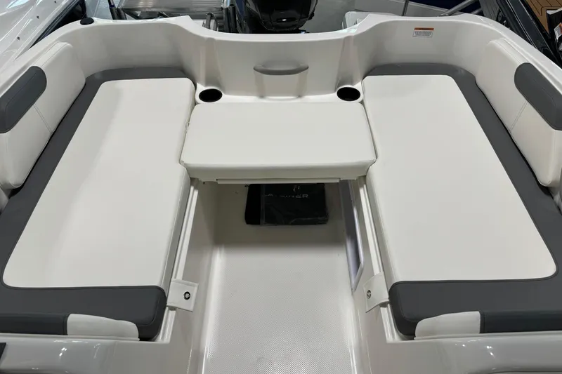 Slide: The Image of 2026 Bayliner Element E18 boat interior with white and gray seating and cup holders. - 5