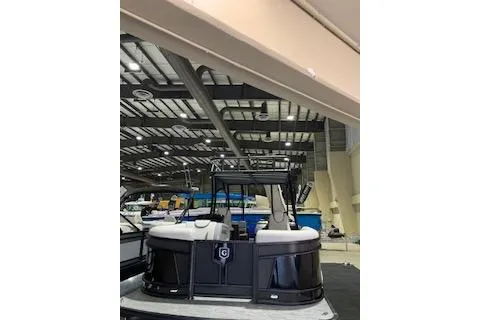 Slide: The Image of 2025 Godfrey Monaco 235 SD pontoon boat displayed in an indoor showroom. - 1