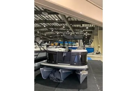 Slide: The Image of 2025 Godfrey Monaco 235 SD pontoon boat displayed in a showroom. - 2