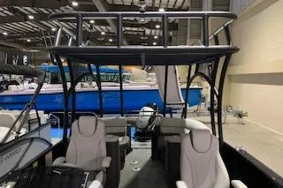 Slide: The Image of 2025 Godfrey Monaco 235 SD boat interior with seating and helm, showcased indoors. - 7