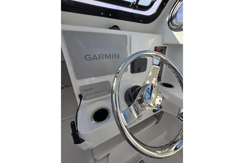 Slide: The Image of Steering wheel and Garmin display on 2026 Parker 247 Explorer boat dashboard. - 25