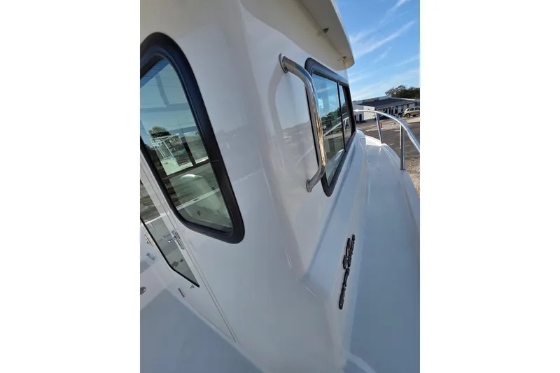 Slide: The Image of 2026 Parker 247 Explorer boat exterior with windows and railing under clear sky. - 30
