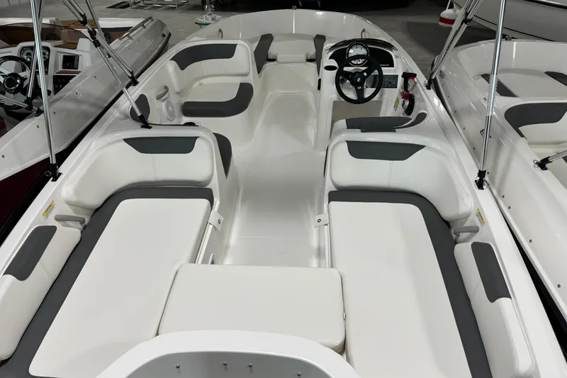Slide: The Image of 2026 Bayliner Element E18 boat interior with white and gray seating, steering wheel, and spacious layout. - 11