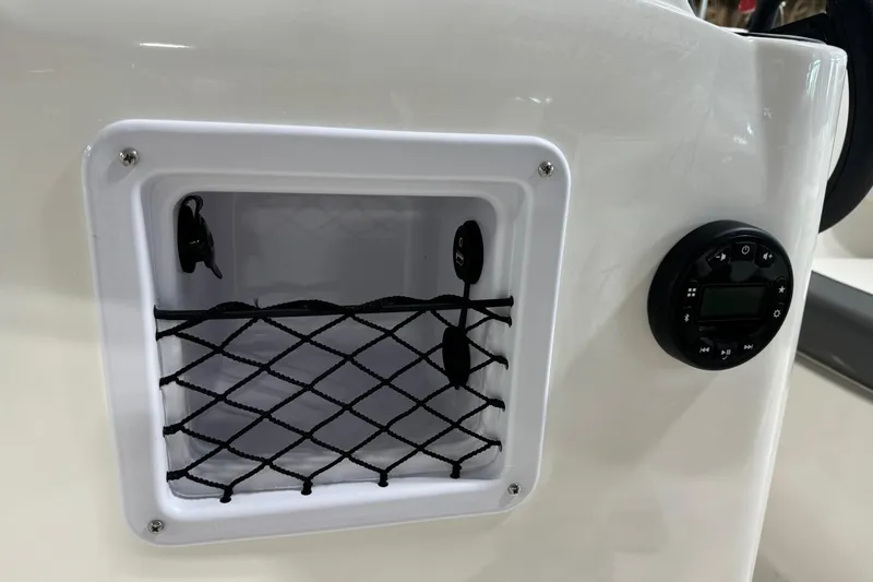 Slide: The Image of 2026 Bayliner Element E18 boat storage compartment with netting and control panel. - 15