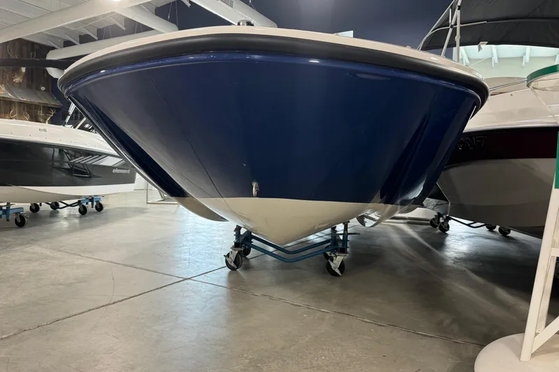 Slide: The Image of 2026 Bayliner Element E18 boat displayed indoors on wheeled supports. - 3