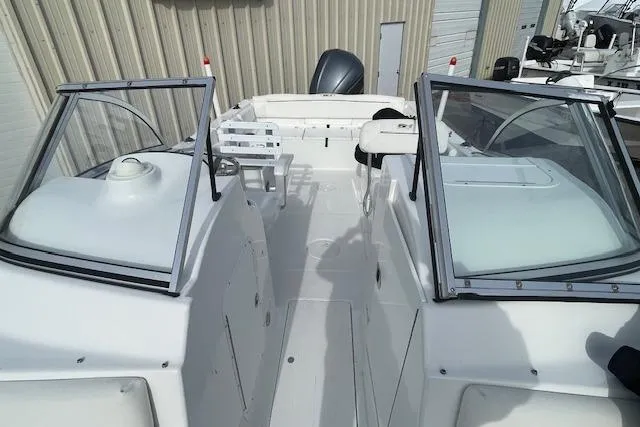 Slide: The Image of 2016 Seahunt 235 Escape DC boat with open deck and dual consoles. - 11