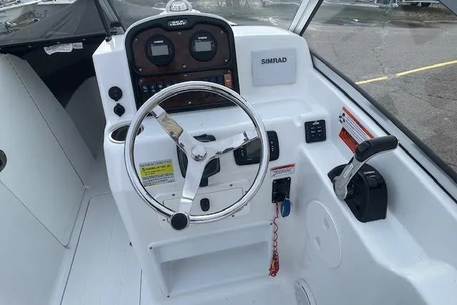 Slide: The Image of 2016 Seahunt 235 Escape DC boat cockpit with steering wheel and controls. - 12
