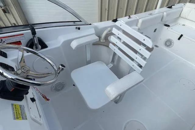 Slide: The Image of 2016 Seahunt 235 Escape DC boat interior with white captain's chair and steering wheel. - 22