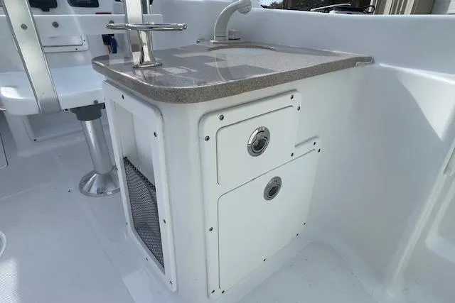 Slide: The Image of 2016 Seahunt 235 Escape DC boat interior with sink and storage compartments. - 28