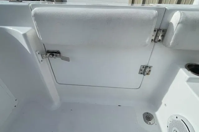 Slide: The Image of 2016 Seahunt 235 Escape DC boat interior, featuring white seating and storage compartment. - 30