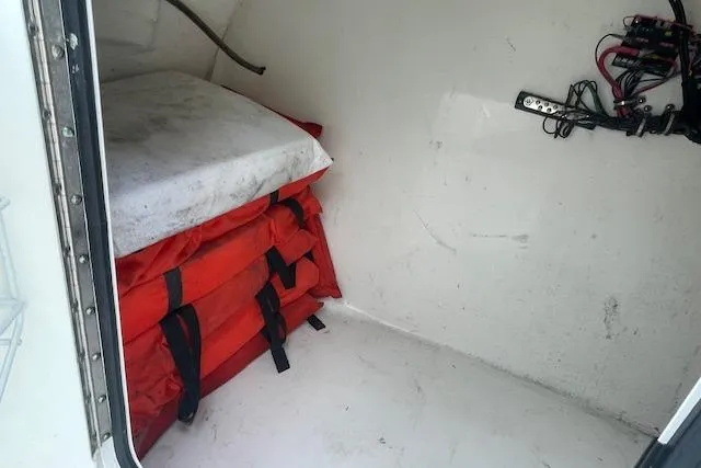 Slide: The Image of Storage compartment in 2016 Seahunt 235 Escape DC with life jackets and wiring. - 35