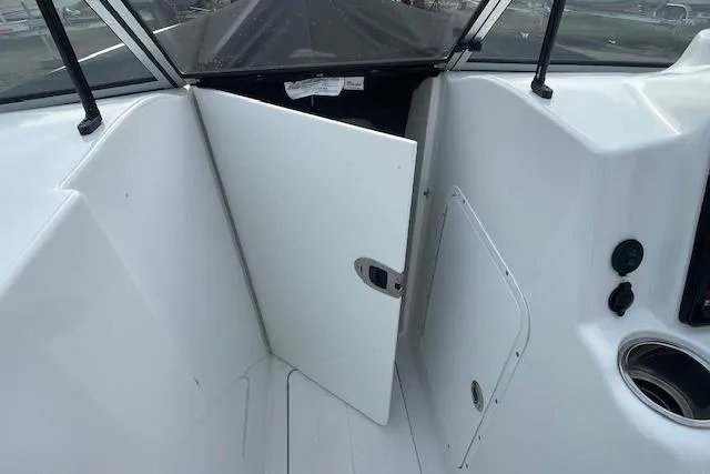 Slide: The Image of 2016 Seahunt 235 Escape DC boat interior with open cabin door and cup holder. - 37