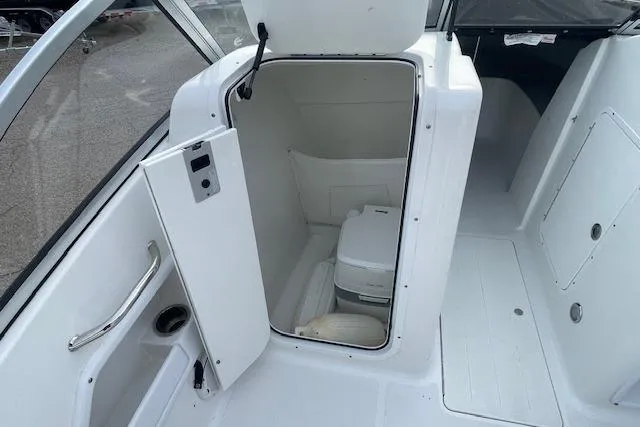 Slide: The Image of 2016 Seahunt 235 Escape DC boat interior with open storage compartment and portable toilet. - 40