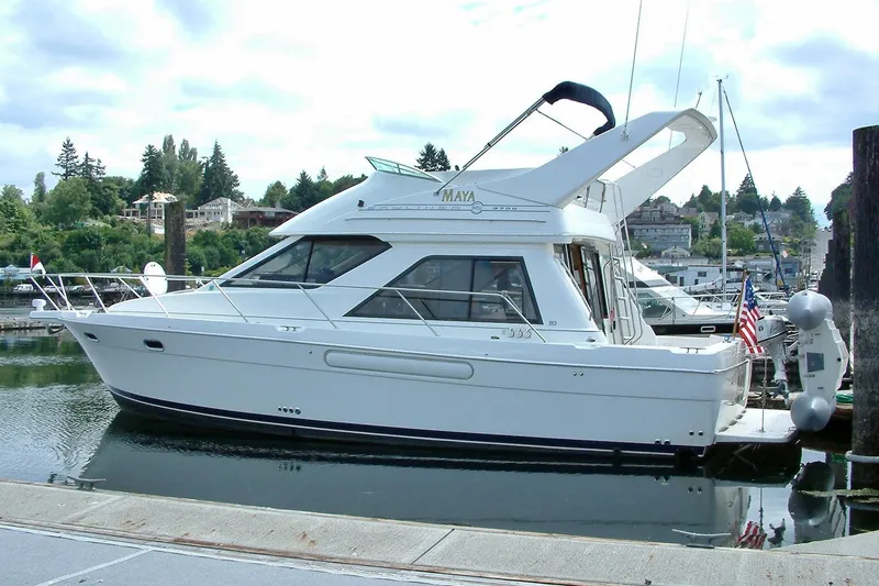 Slide: The Image of 1998 Bayliner 3788 Command Bridge Motoryacht docked in a scenic marina. - 1