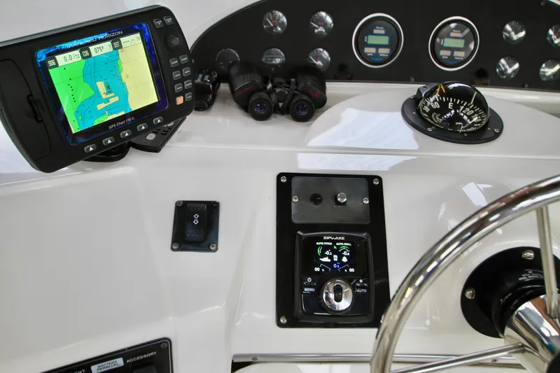 Slide: The Image of 1998 Bayliner 3788 Command Bridge Motoryacht with inflatable boat and American flag in docked setting. - 19