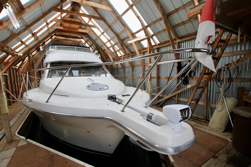 Slide: The Image of 1998 Bayliner 3788 Command Bridge Motoryacht docked in a wooden boathouse. - 2