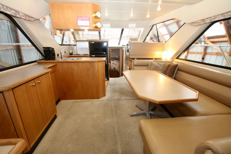Slide: The Image of 1998 Bayliner 3788 Command Bridge Motoryacht interior with white seating and water view. - 28