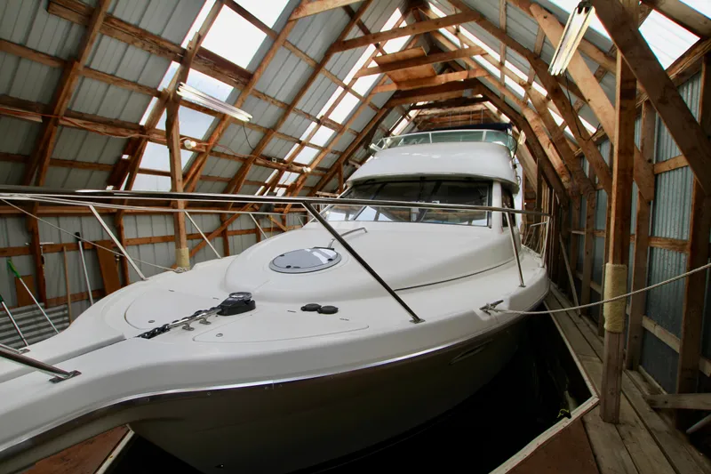 Slide: The Image of 1998 Bayliner 3788 Command Bridge Motoryacht docked in a wooden boathouse. - 4