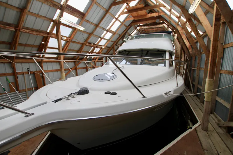 Slide: The Image of 1998 Bayliner 3788 Command Bridge Motoryacht docked in a wooden boathouse. - 5