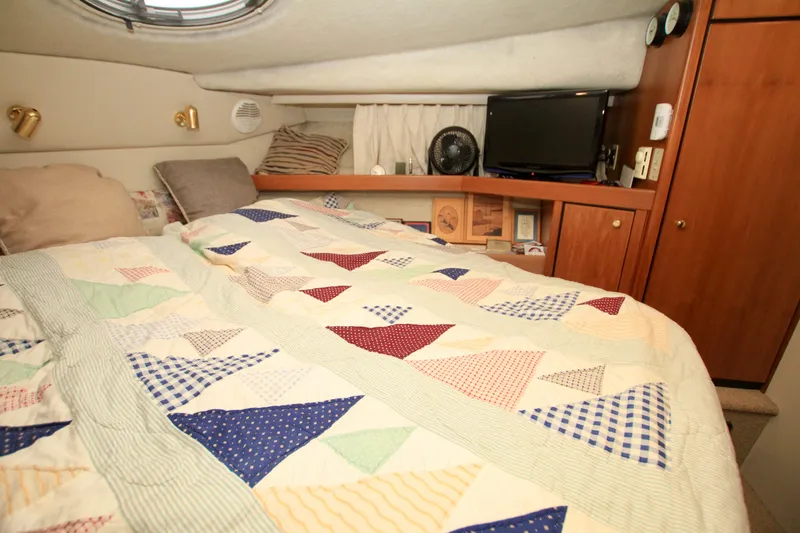 Slide: The Image of Cozy bedroom in 1998 Bayliner 3788 Command Bridge Motoryacht with quilted bedding and wooden cabinetry. - 58