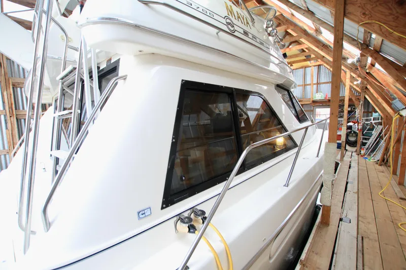 Slide: The Image of 1998 Bayliner 3788 Command Bridge Motoryacht docked in a wooden boathouse. - 7