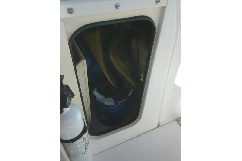 Slide: The Image of Storage compartment on a 2004 Grady-White Fisherman 209 boat with visible fire extinguisher. - 30