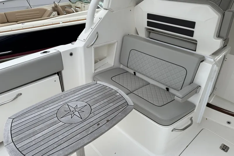 Slide: The Image of 2022 Pursuit DC 365 Dual Console interior with gray seating and wooden table. - 10