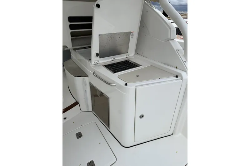 Slide: The Image of 2022 Pursuit DC 365 Dual Console boat interior with sleek white cabinetry and storage. - 11