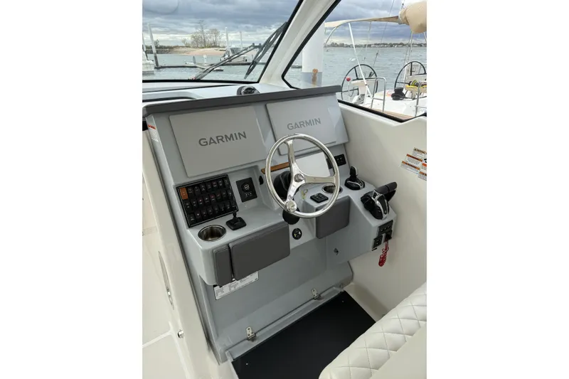 Slide: The Image of 2022 Pursuit DC 365 Dual Console helm with Garmin navigation system, steering wheel, and controls. - 14