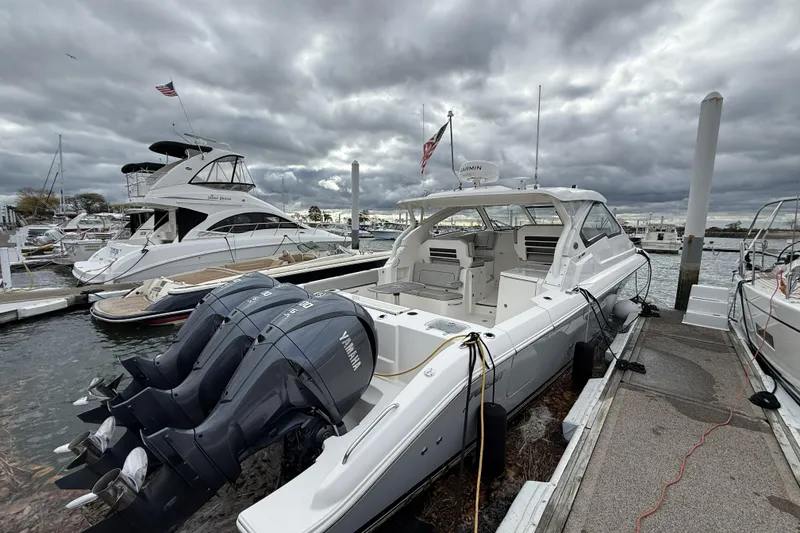 Slide: The Image of 2022 Pursuit DC 365 Dual Console boat docked with Yamaha engines under cloudy skies. - 8