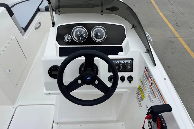 Slide: The Image of 2026 Bayliner M19 boat dashboard with steering wheel and control panel. - 16