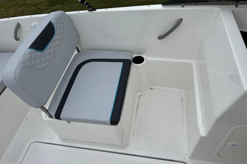 Slide: The Image of 2026 Bayliner M19 boat interior with cushioned seating and cup holder. - 12