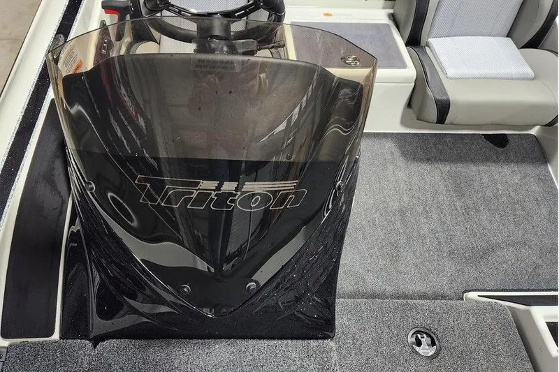 Slide: The Image of 2026 Triton 179 TrX boat interior with steering console and seating. - 11