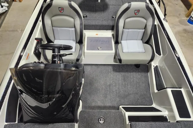 Slide: The Image of 2026 Triton 179 TrX boat interior with dual seats and steering console. - 13