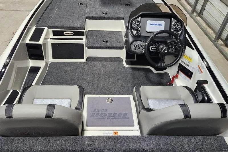 Slide: The Image of 2026 Triton 179 TrX boat interior with steering console and seating, featuring Lowrance electronics. - 8