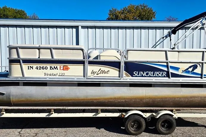 Slide: The Image of 1999 Lowe Trinidad 220 Suncruiser pontoon boat on trailer, parked outdoors. - 11