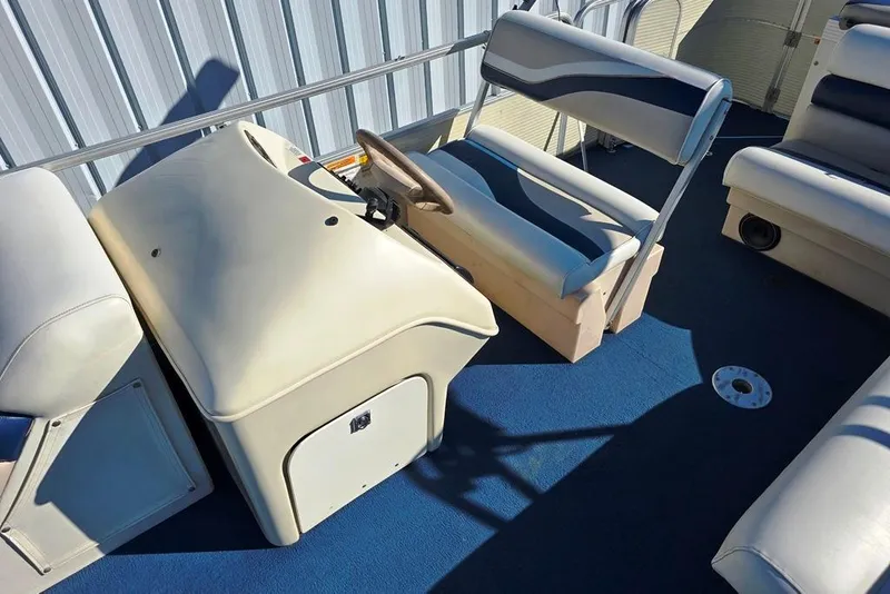 Slide: The Image of 1999 Lowe Trinidad 220 boat interior with blue and white seating and steering console. - 2