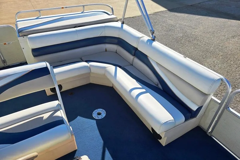 Slide: The Image of 1999 Lowe Trinidad 220 pontoon boat with white and blue seating on a sunny day. - 4