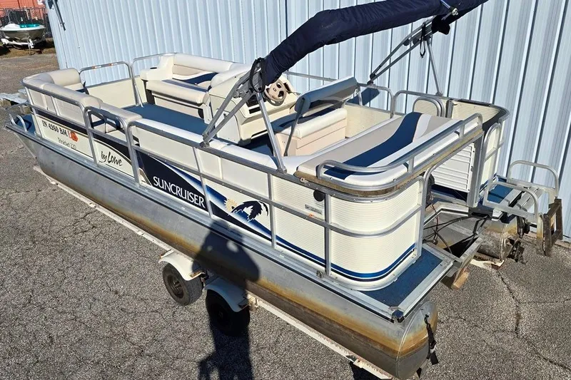 Slide: The Image of 1999 Lowe Trinidad 220 pontoon boat on trailer, parked outdoors. - 6