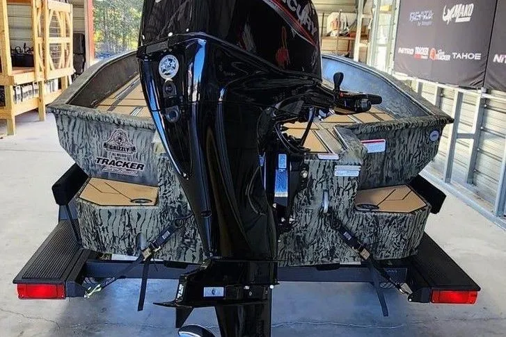 Slide: The Image of 2026 Tracker Grizzly 1756 T Marsh boat with camouflage design and powerful outboard motor. - 2