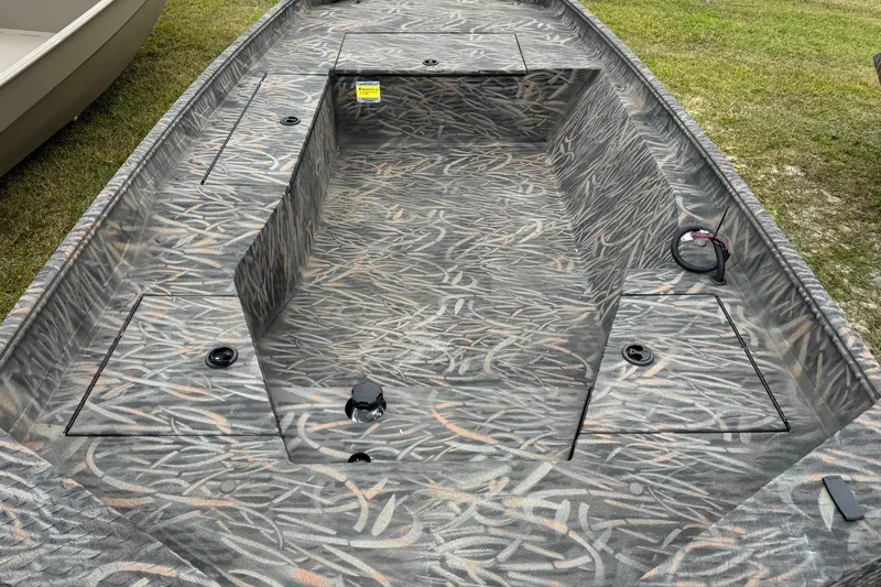 Slide: The Image of 2026 Alweld 1548VV Marsh boat interior with motor, parked on concrete. - 7