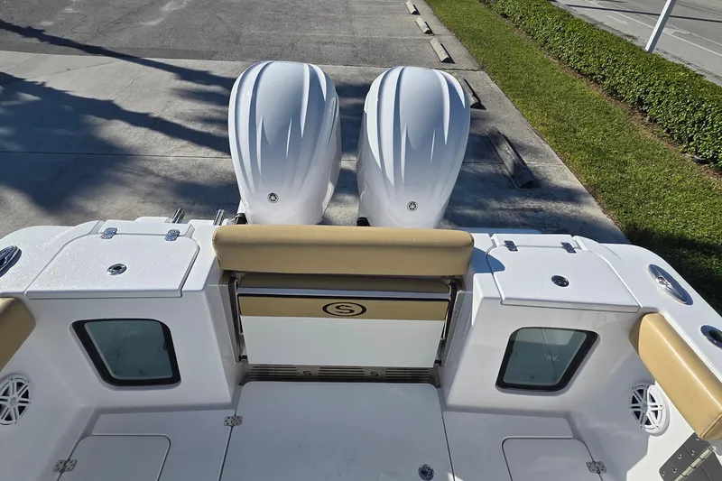 Slide: The Image of 2022 Sportsman Open 282TE Center Console boat with dual engines, docked on pavement. - 11