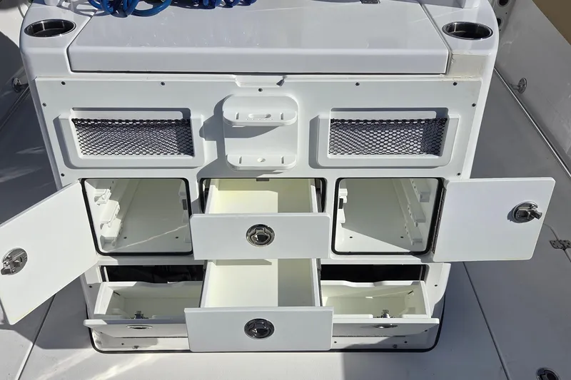 Slide: The Image of 2022 Sportsman Open 282TE Center Console storage compartments with open drawers and doors. - 12